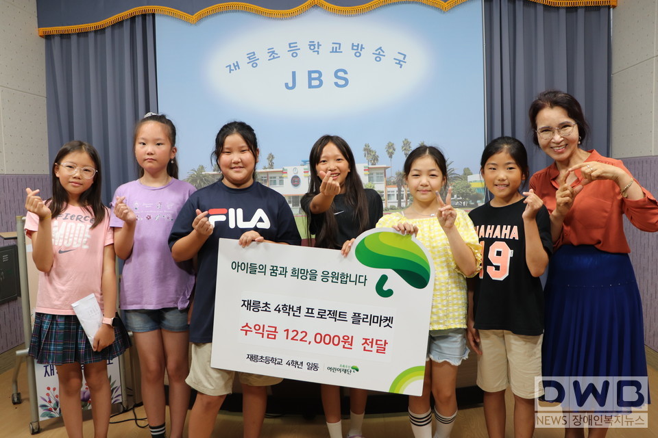 지난 24일(월) 재릉초등학교 4학년 학생들과 강미숙 교장(맨 오른쪽)이 함께 후원금 전달식을 진행하고 기념사진을 촬영했다.